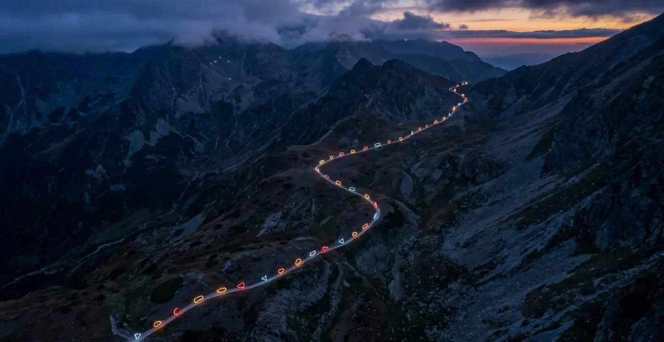 Vue aérienne d'un sentier balisé serpentant comme une ligne de vie dans un paysage montagneux sauvage